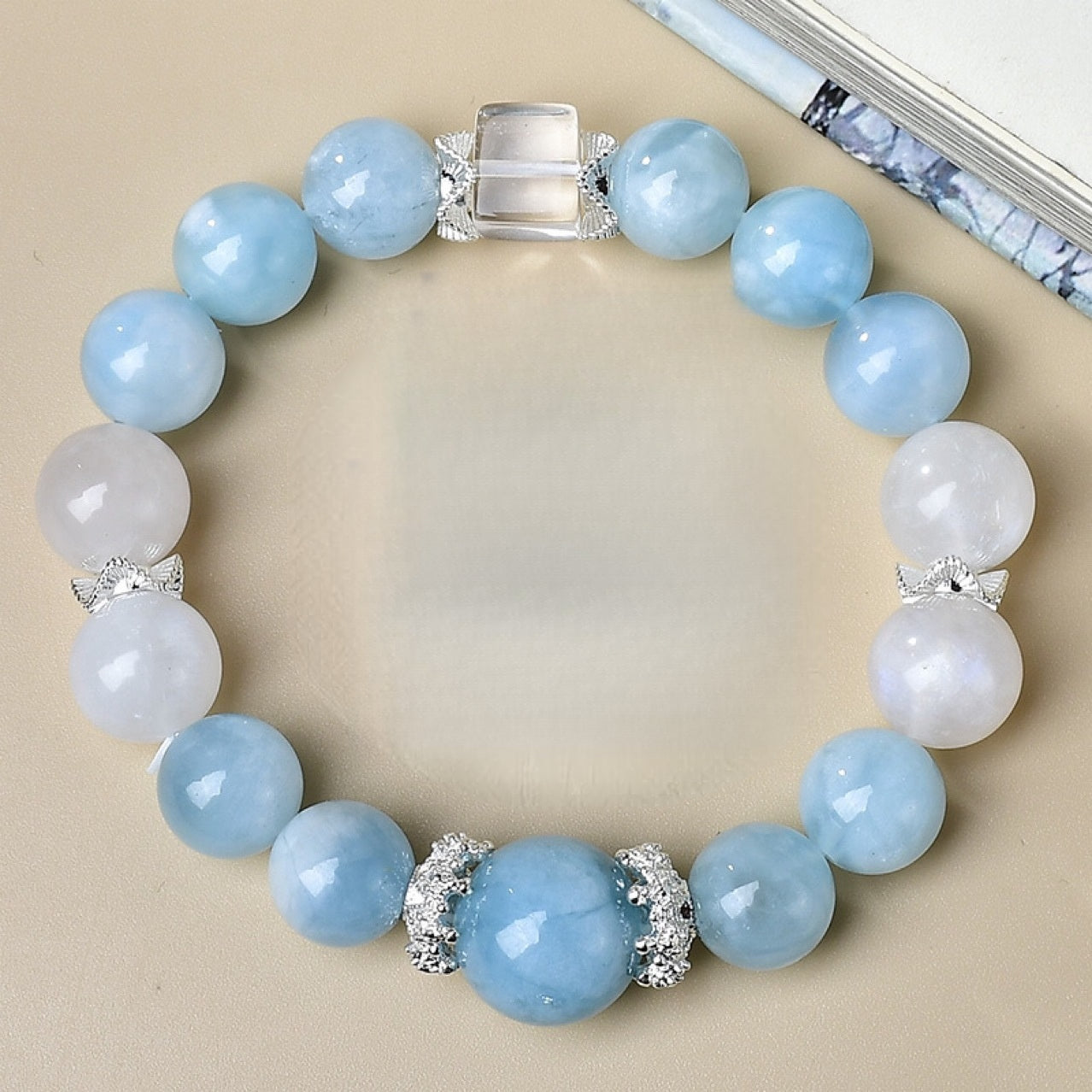 Close-up of pale blue Aquamarine and grey-blue Moonstone beads, calming crystal bracelet on wrist.